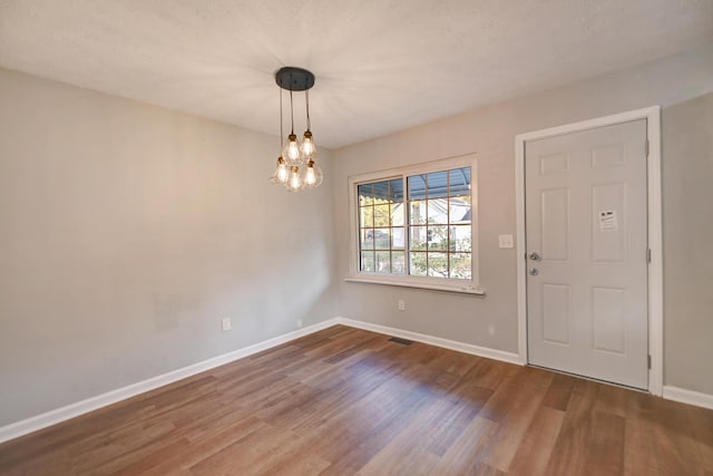 foyer featuring wood-type flooring and a chandelier