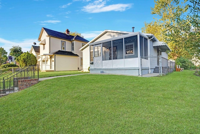 view of front of home with a front lawn and a sunroom