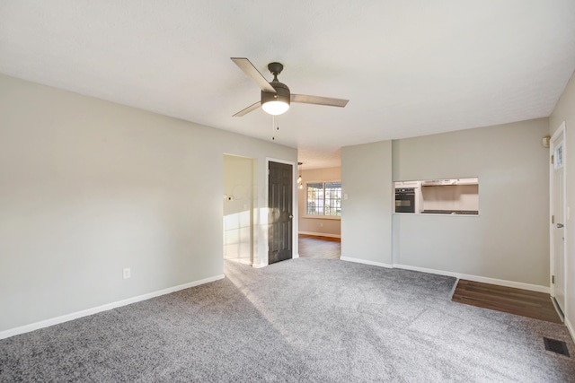 unfurnished bedroom with ceiling fan, ensuite bathroom, and dark colored carpet