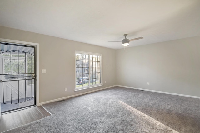 carpeted empty room featuring a wealth of natural light and ceiling fan