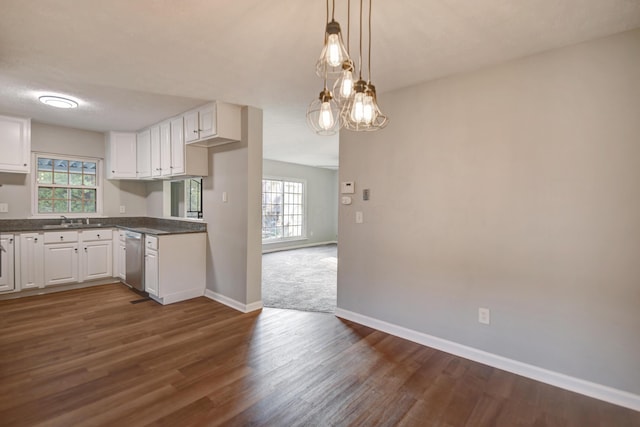 kitchen featuring decorative light fixtures, sink, white cabinetry, and dark wood-type flooring