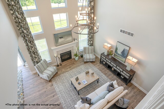 living room featuring a chandelier, a high ceiling, and light wood-type flooring