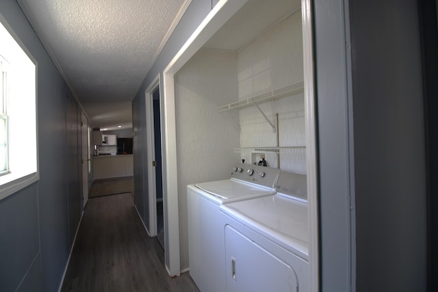 laundry area with a textured ceiling, independent washer and dryer, and dark wood-type flooring