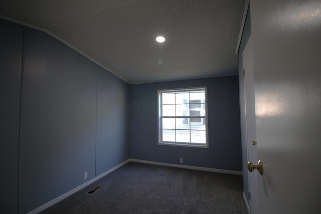 carpeted spare room with a textured ceiling, crown molding, and lofted ceiling