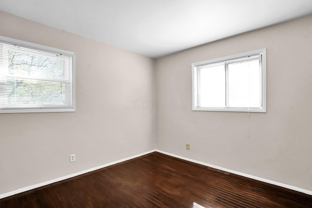 spare room with hardwood / wood-style flooring and plenty of natural light