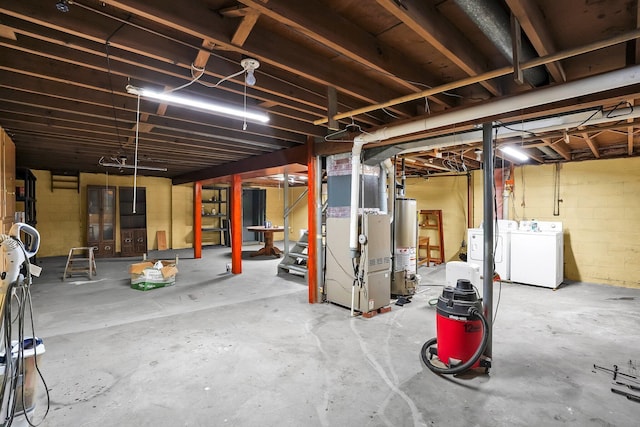 basement with washing machine and dryer, gas water heater, and heating unit