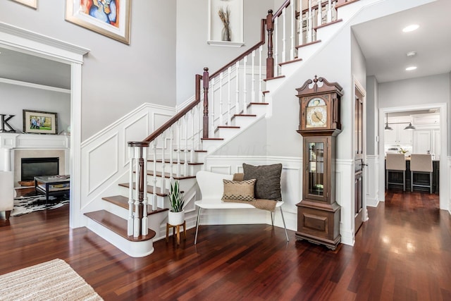 stairs with hardwood / wood-style flooring and ornamental molding