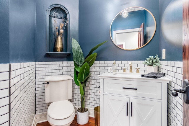 bathroom with vanity, tile walls, and toilet