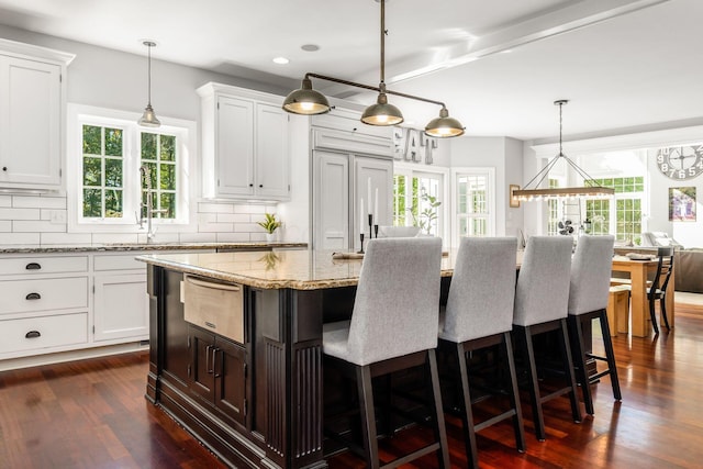 kitchen featuring a center island, white cabinets, and a healthy amount of sunlight