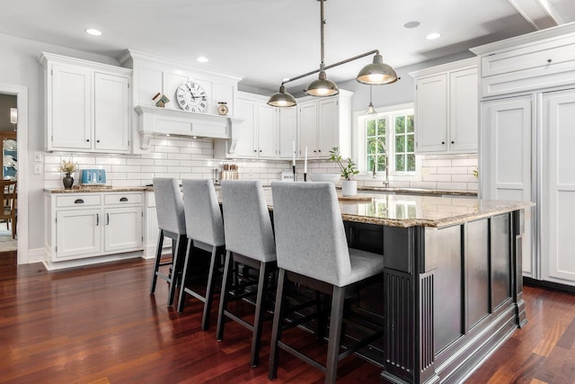 kitchen with white cabinets, decorative backsplash, dark hardwood / wood-style flooring, and hanging light fixtures