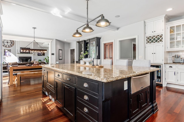 kitchen featuring a center island, dark hardwood / wood-style floors, white cabinetry, and hanging light fixtures