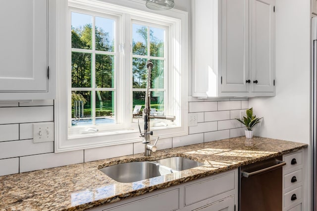 kitchen with dishwasher, white cabinetry, a wealth of natural light, and sink