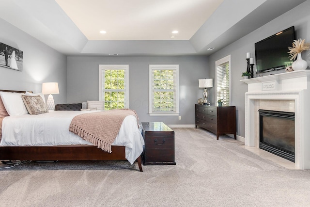 bedroom featuring light carpet and a raised ceiling