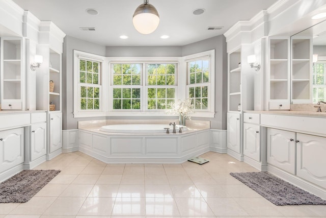 bathroom with tile patterned flooring, vanity, built in features, and a bath