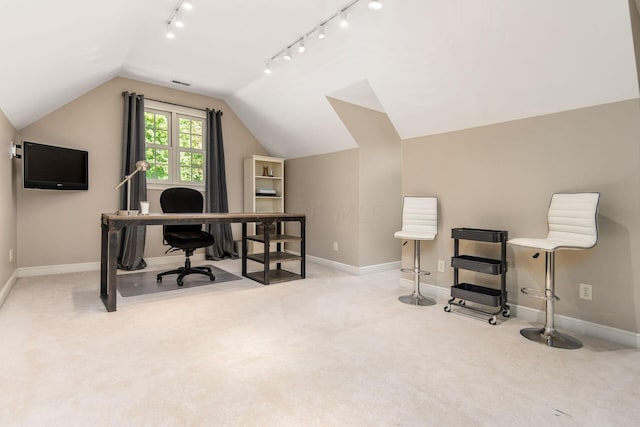 office space with rail lighting, light colored carpet, and lofted ceiling