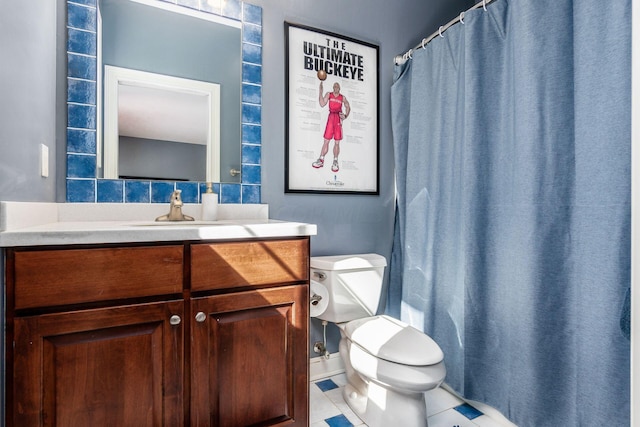 bathroom with tile patterned floors, vanity, toilet, and tasteful backsplash