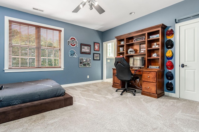 carpeted bedroom with multiple windows and ceiling fan