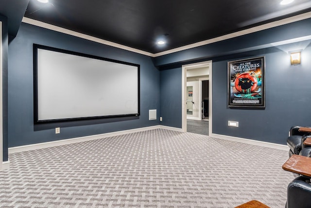 carpeted home theater room featuring crown molding