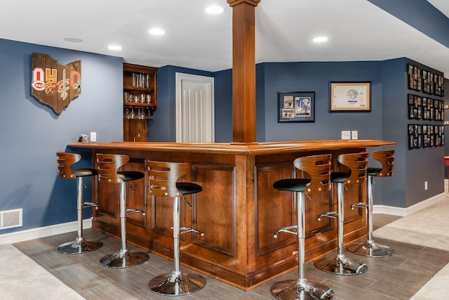 bar featuring carpet floors and ornate columns