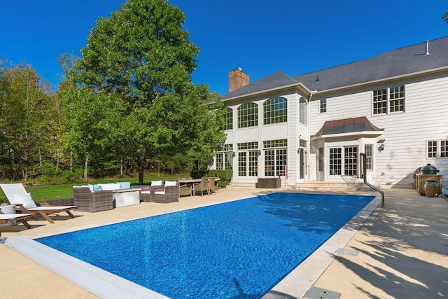 rear view of property with an outdoor living space, french doors, and a patio