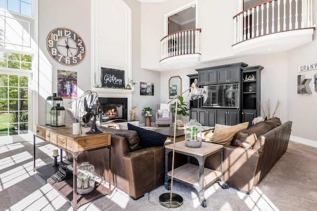 carpeted living room with a towering ceiling and ornamental molding