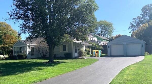 view of front of house featuring an outbuilding, a front lawn, and a garage