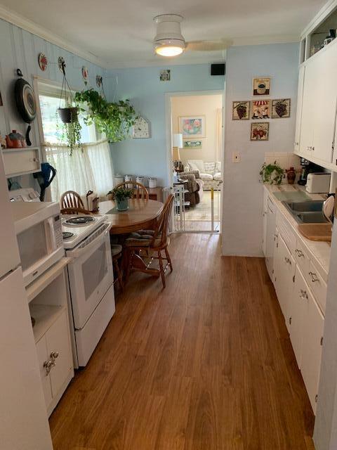 kitchen featuring white cabinetry, sink, dark hardwood / wood-style floors, and white appliances