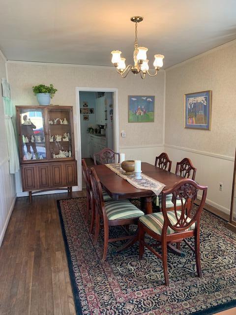 dining room with an inviting chandelier and dark wood-type flooring