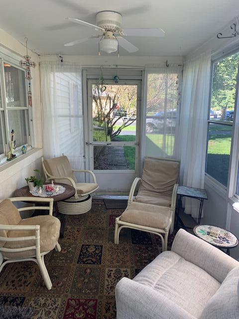 sunroom / solarium featuring plenty of natural light and ceiling fan