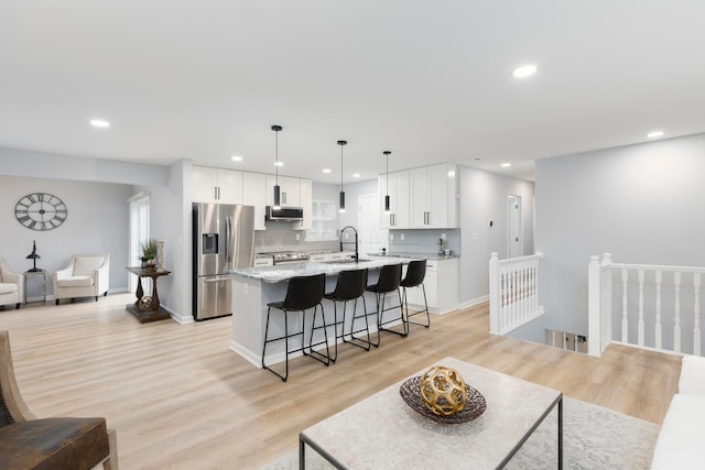 living room with sink and light wood-type flooring