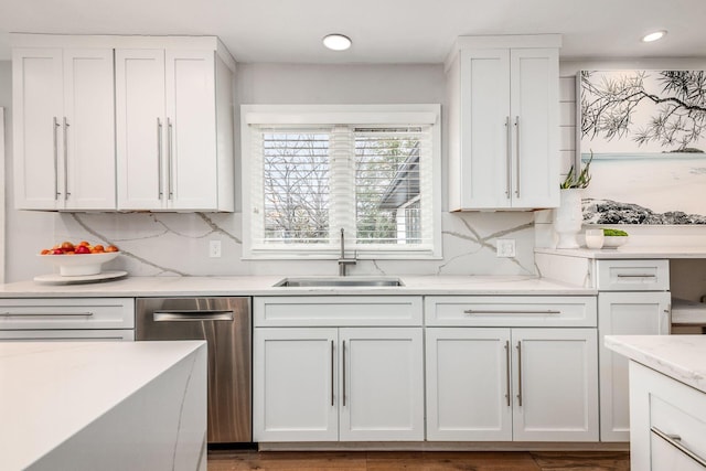 kitchen with dishwasher, white cabinetry, sink, and backsplash