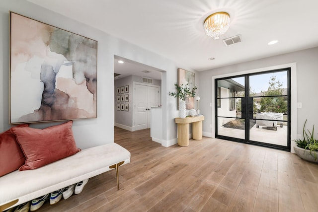 sitting room with a chandelier and light hardwood / wood-style flooring