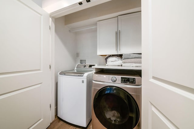 laundry room with cabinets, separate washer and dryer, and light hardwood / wood-style floors