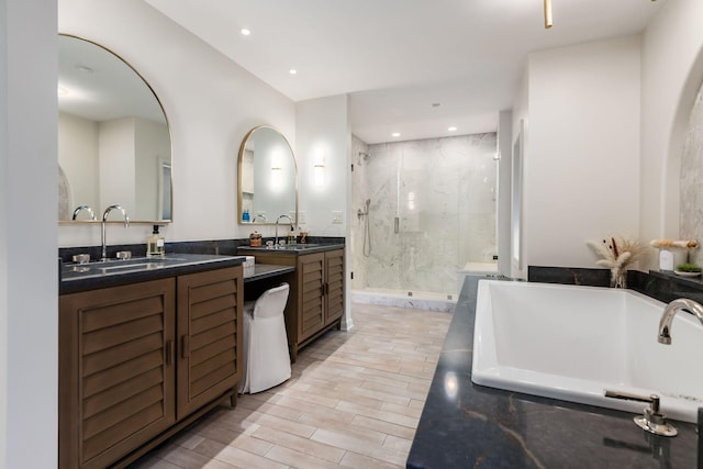 bathroom with vanity and shower with separate bathtub