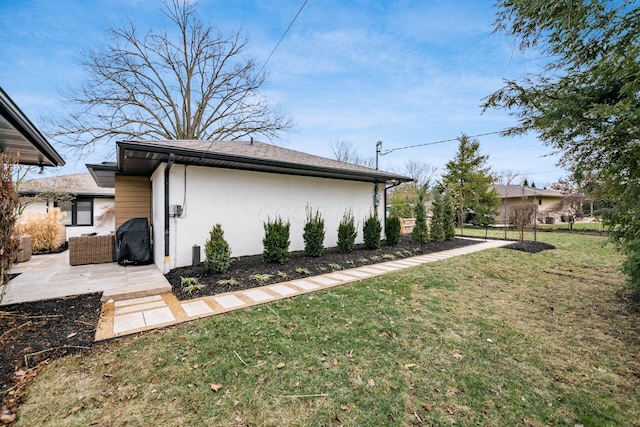 view of side of property featuring a yard and a patio area