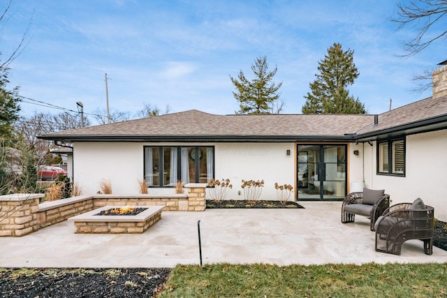 rear view of house featuring a patio area and an outdoor fire pit