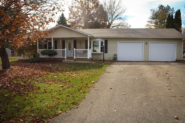 single story home with covered porch, a front yard, and a garage