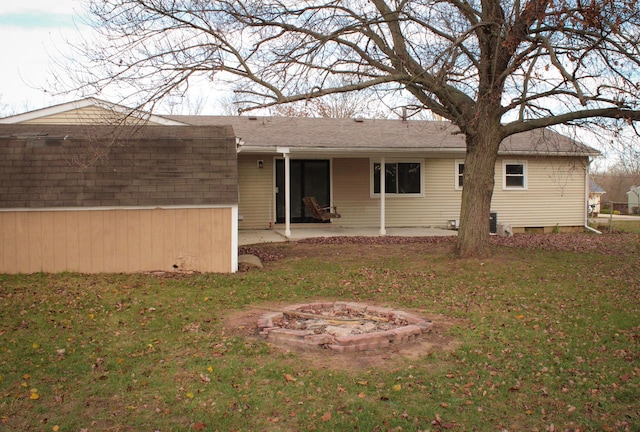 back of house with a lawn, a patio area, and an outdoor fire pit