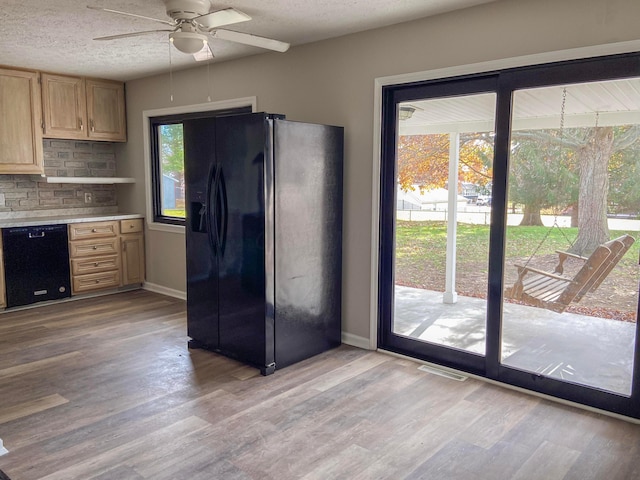 kitchen featuring ceiling fan, light brown cabinets, tasteful backsplash, light hardwood / wood-style floors, and black appliances