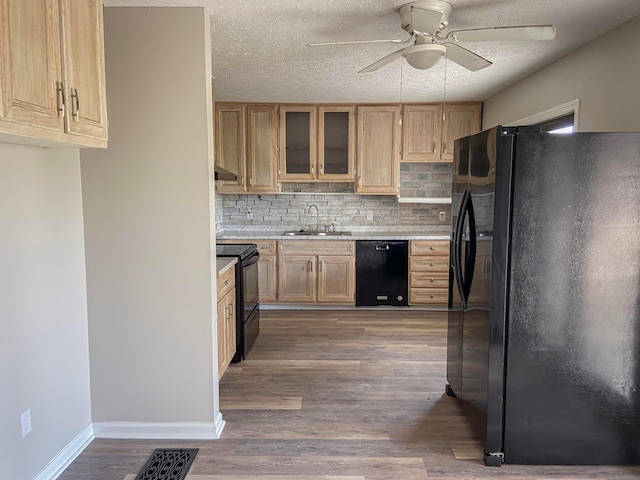 kitchen with ceiling fan, sink, dark hardwood / wood-style flooring, decorative backsplash, and black appliances