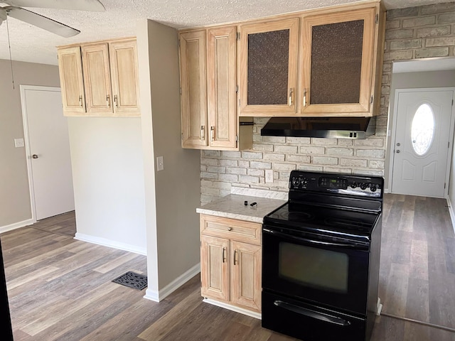 kitchen featuring dark hardwood / wood-style flooring, black electric range oven, extractor fan, and a textured ceiling