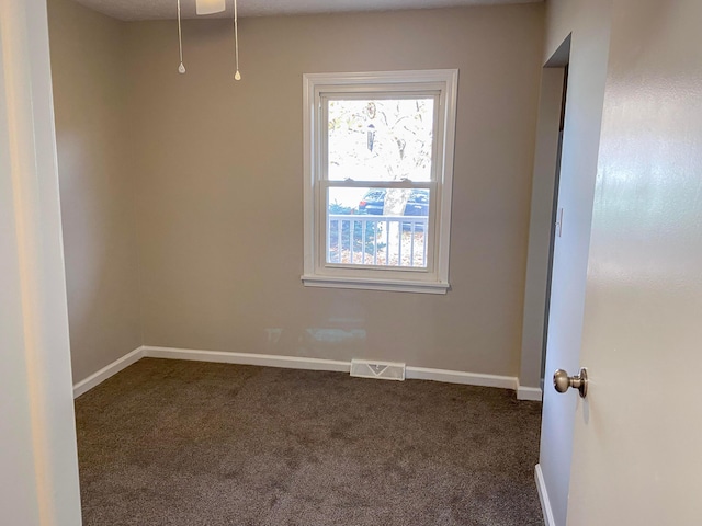 empty room featuring dark carpet