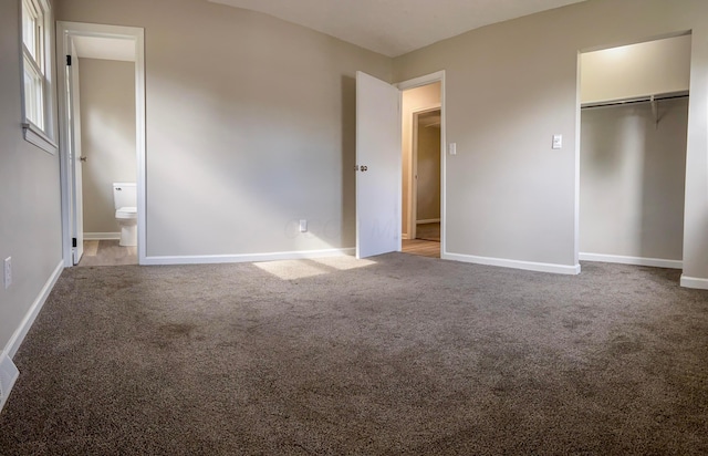 unfurnished bedroom featuring a spacious closet, carpet floors, connected bathroom, and a closet