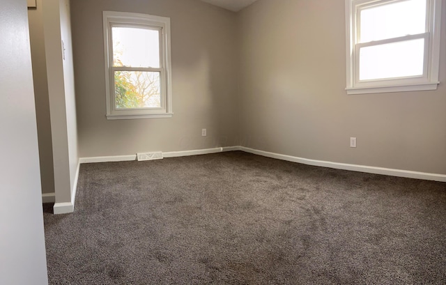 spare room with dark colored carpet