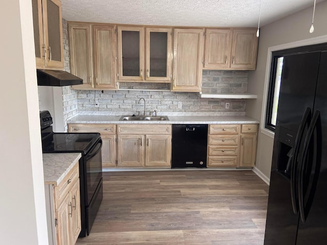 kitchen featuring sink, light brown cabinets, decorative backsplash, black appliances, and hardwood / wood-style flooring