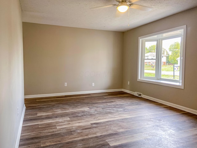 unfurnished room featuring a textured ceiling, dark hardwood / wood-style flooring, and ceiling fan