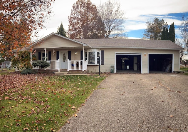 single story home featuring covered porch, a garage, and a front yard