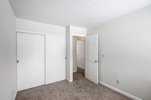 unfurnished bedroom with a closet and carpet