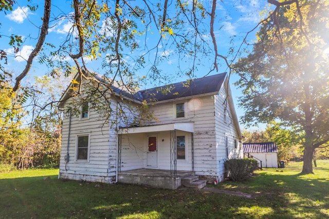 view of front of house with a shed and a front lawn