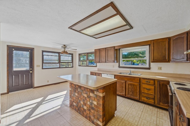 kitchen featuring ceiling fan, a center island, sink, range with electric stovetop, and a textured ceiling